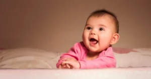 Smiling Baby Lying on Bed in Room