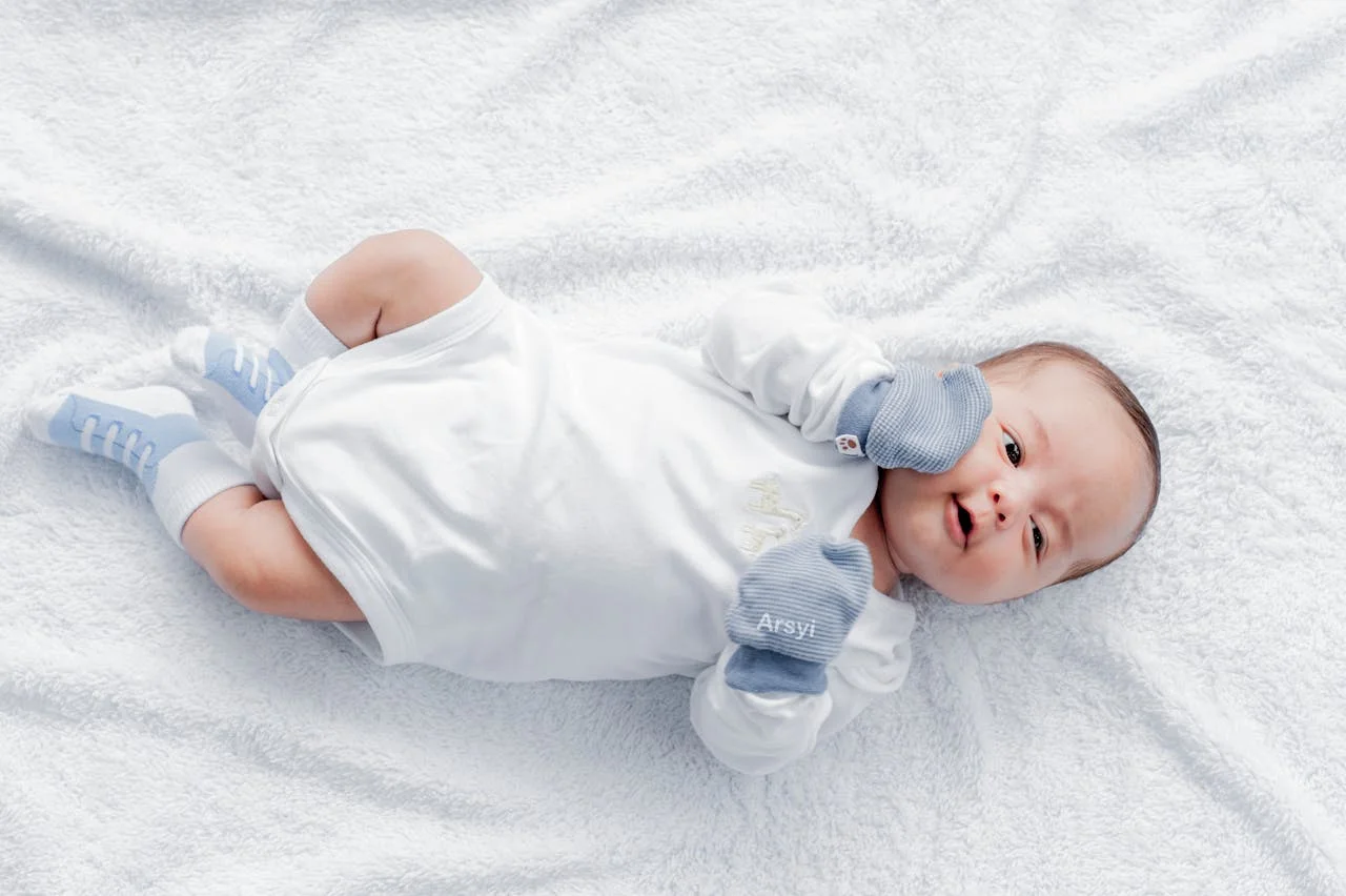 A Newborn Baby Lying on a White Blanket